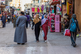 Women walking through a busy street market in Egypt